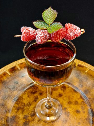 cocktail garnished with raspberries