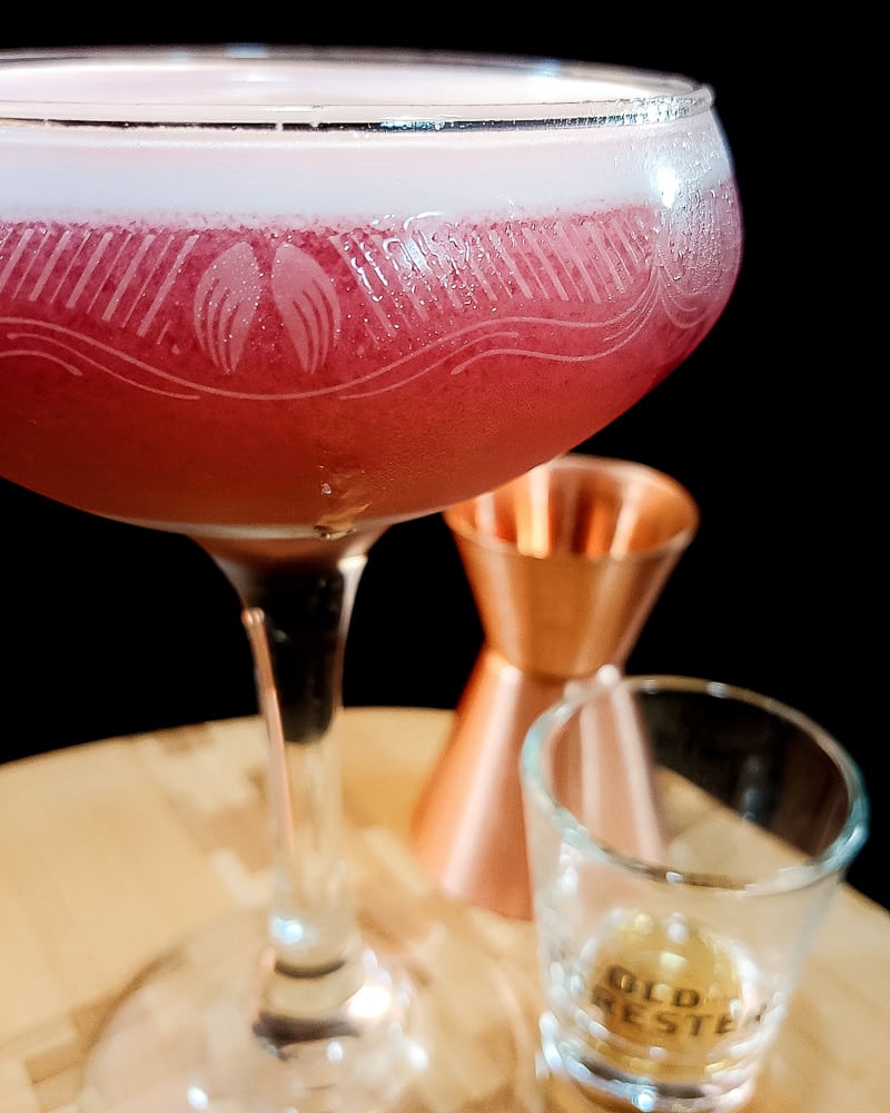 pink whiskey cocktail in a coupe glass