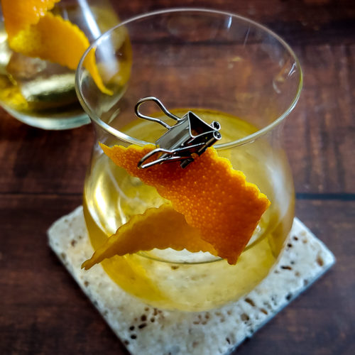 tequila cocktail with orange garnish
