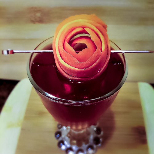 cocktail garnished with orange rose