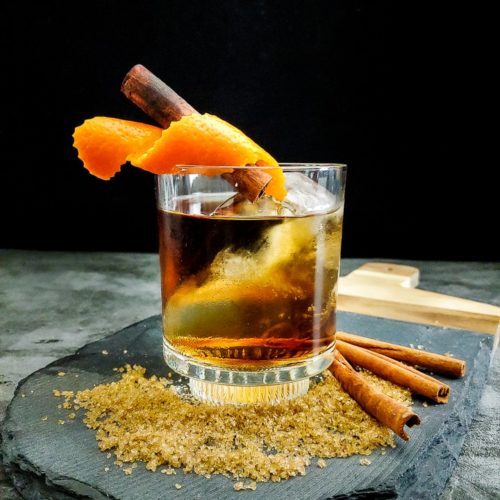 old fashioned cocktail with orange and cinnamon garnish
