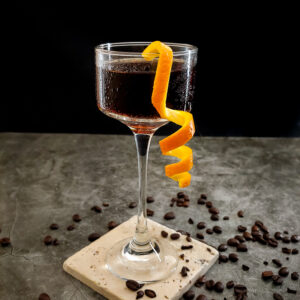 cocktail in glass wih orange garnish