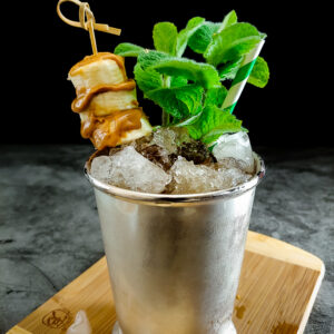 cocktail in julep cup with banana peanut butter garnish
