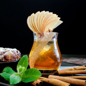 apple fan on whiskey cocktail with cinna mon sticks