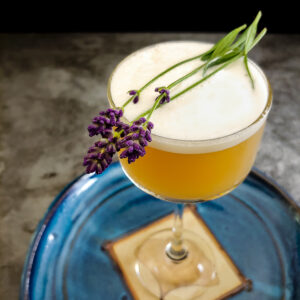 foam topped whiskey sour with lavender sprig