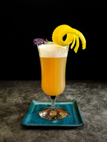 rye whiskey sour with lemon and lavender garnish
