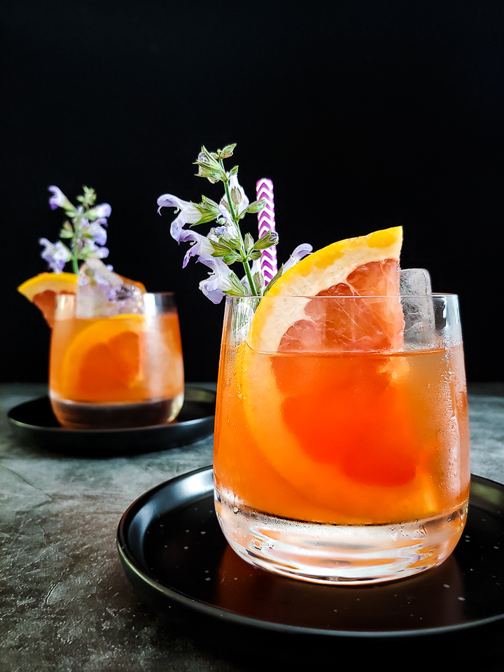 grapefruit mezcal cocktail with grapefuit and sage flower garnish