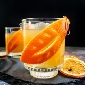 old fashioned cocktail with orange leaf garnish