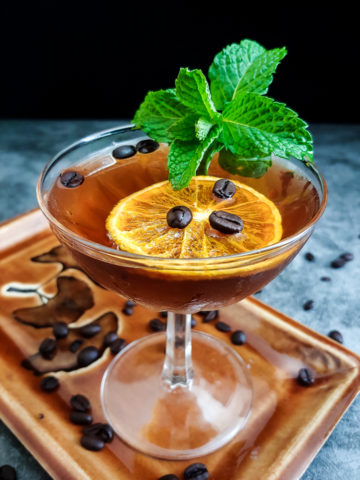 rum cocktail with mint and orange chip garnish