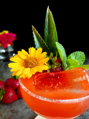 strawberry cocktail with fresh flowers, ming and strawberry garnish