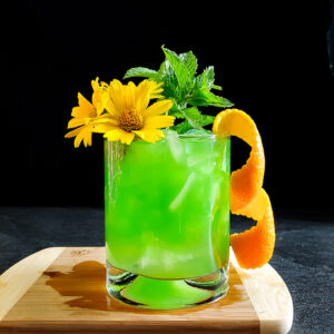 a green mule with mint, orange and flower garnish