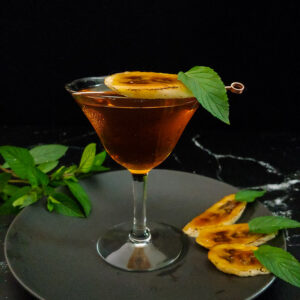 Bananas Foster Manhattan garnished with mint and carmelized banana slices