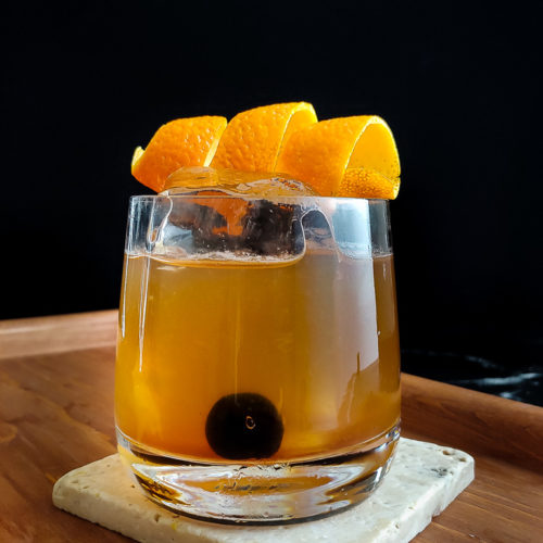 orange twist placed on the top of a classic whiskey sour