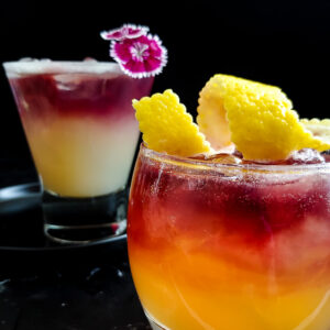 Two versions of New Your Sour garnished with flower and lemon