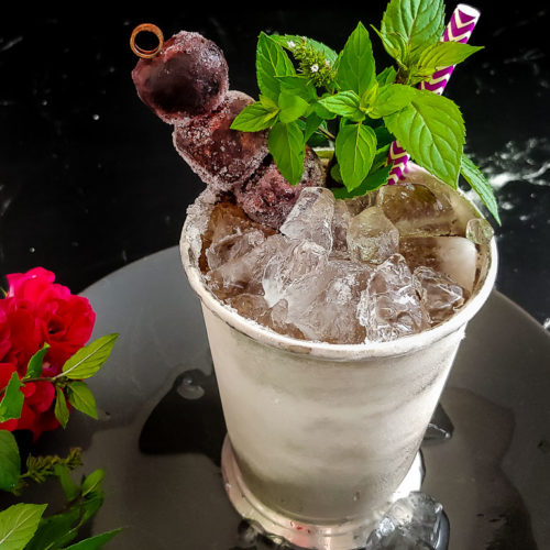 cherry mint julep in julep cup, garnished with mint and cherries