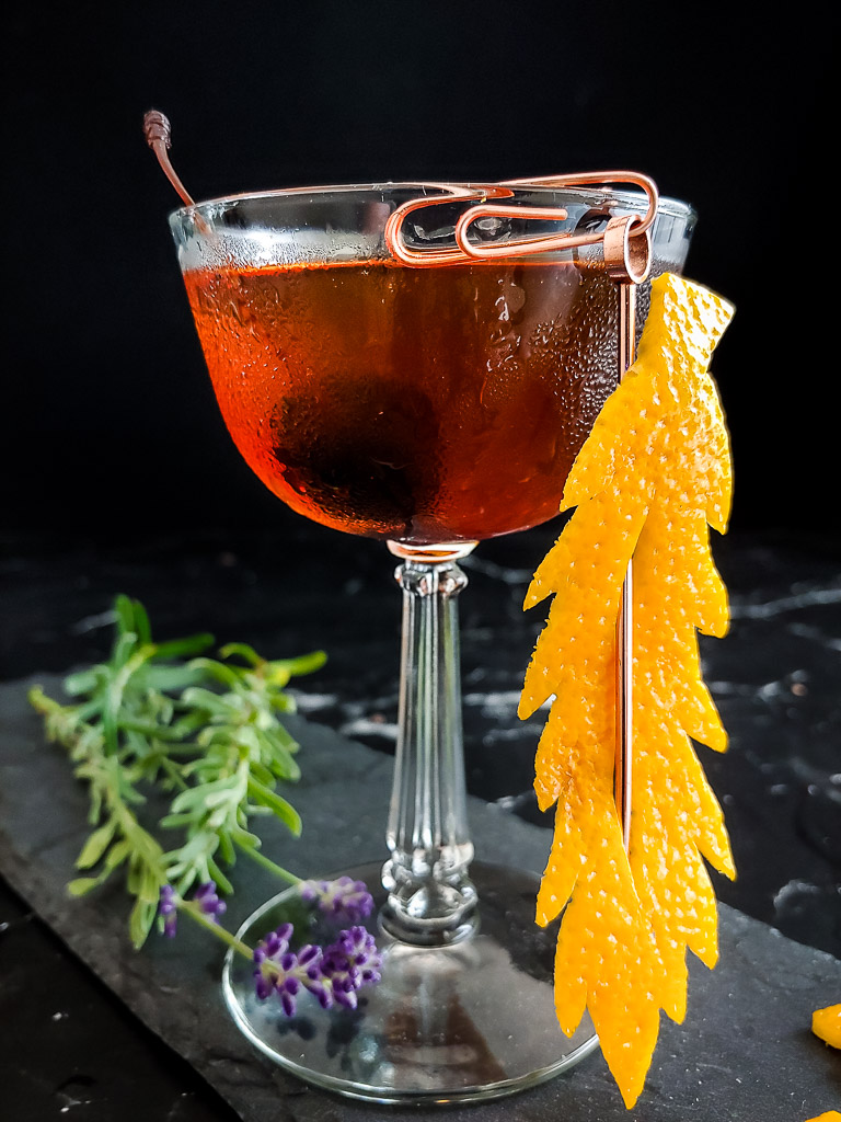 barrel proof manhattan cocktail in a coupe with an orange peel garnish