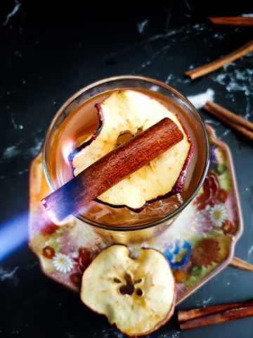 Cynar Old Fashioned with apple garnish and burnt cinnamon stick