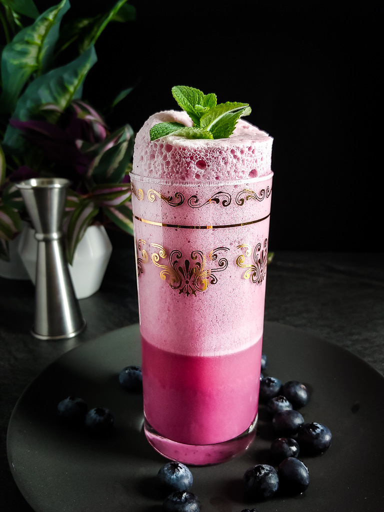 Blueberry Ramos Gin Fizz Mocktail with blueberries and mint garnish
