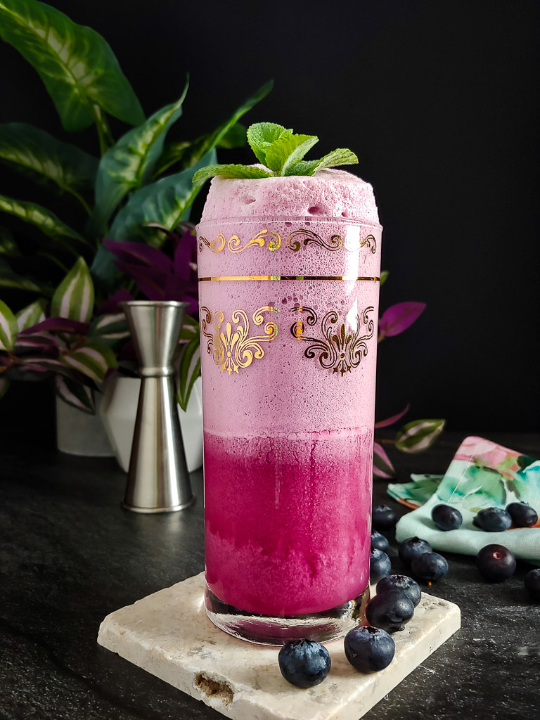 Blueberry Ramos Gin Fizz Mocktail with blueberries and mint garnish