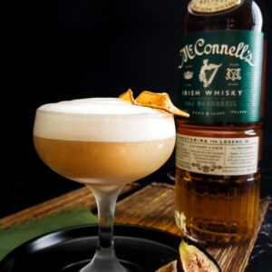 Fig and Pear Whiskey Sour with foam, McConnell's whisky bottled and dried pear garnish