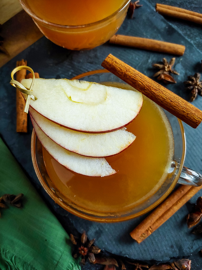 hot apple cider cocktail with apple and cinnamon garnish