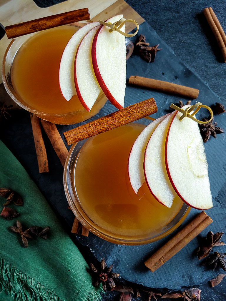 hot apple cider cocktail with apple and cinnamon garnish