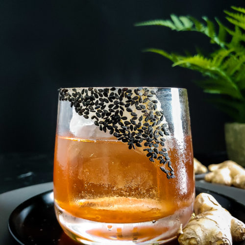 Fernet Sazerac cocktail garnished with sesame seed and ginger powder rim in rocks glass