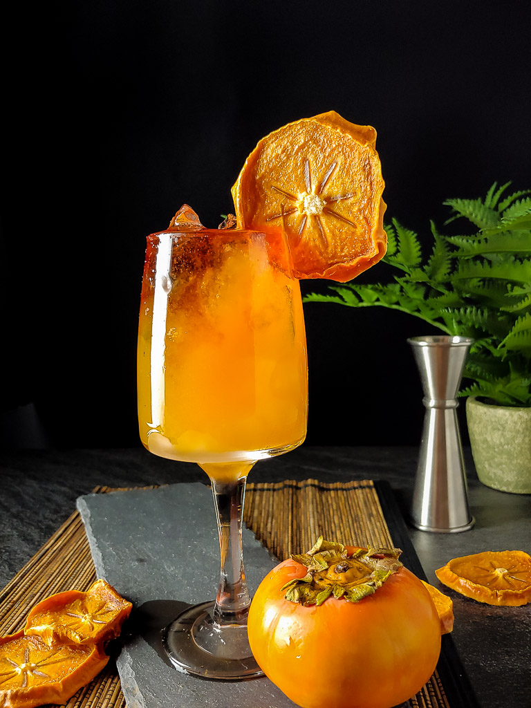 Persimmon Bourbon Cocktail with dried persimmon chip as garnish