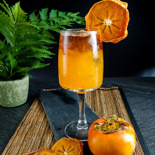 Persimmon Bourbon Cocktail with ice and dried persimmon chip garnish