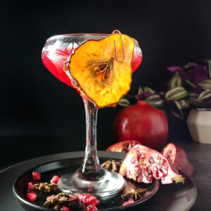 Pomegranate Brandy Sour in a coupe glass with a dried pear garnish
