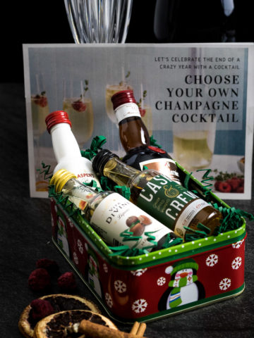 DIY Champagne Cocktail Kit example picture with small tin with 4 flavored liqueurs and dried fruit garnish
