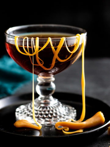 Salted Caramel Manhattan cocktail in a coupe glass with a drizzle of sea salt caramels in it