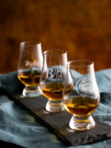 bourbon in three glencairns on a slate tray