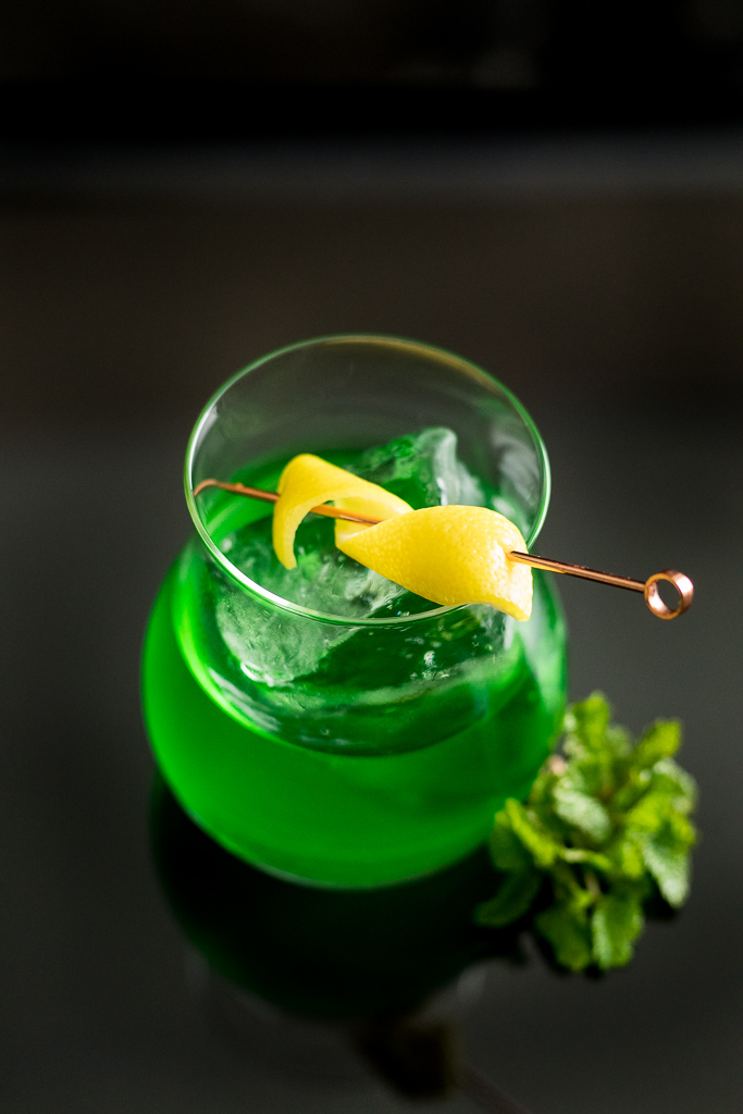 Pissed Leprechaun - Green Suze Cocktail on ice with lemon twist