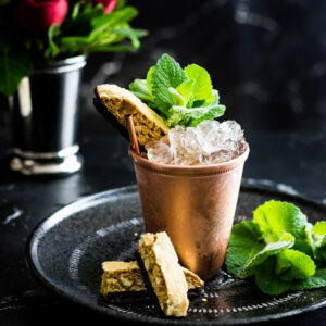 Amaretto Julep in a copper cup with mint and biscotti garnish