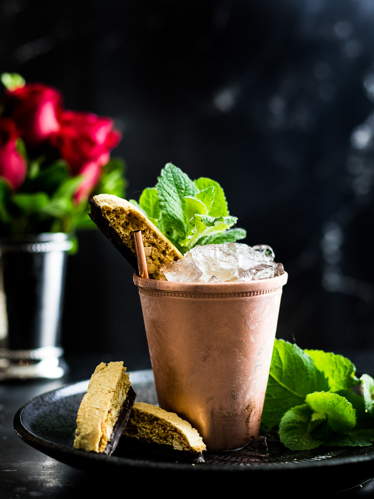 Amaretto Julep in a copper cup with mint and biscotti garnish