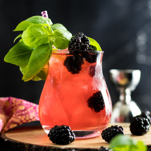 Blackberry Basil Julep - dark pink cocktail in a rocks glass with blackberry and basil garnish