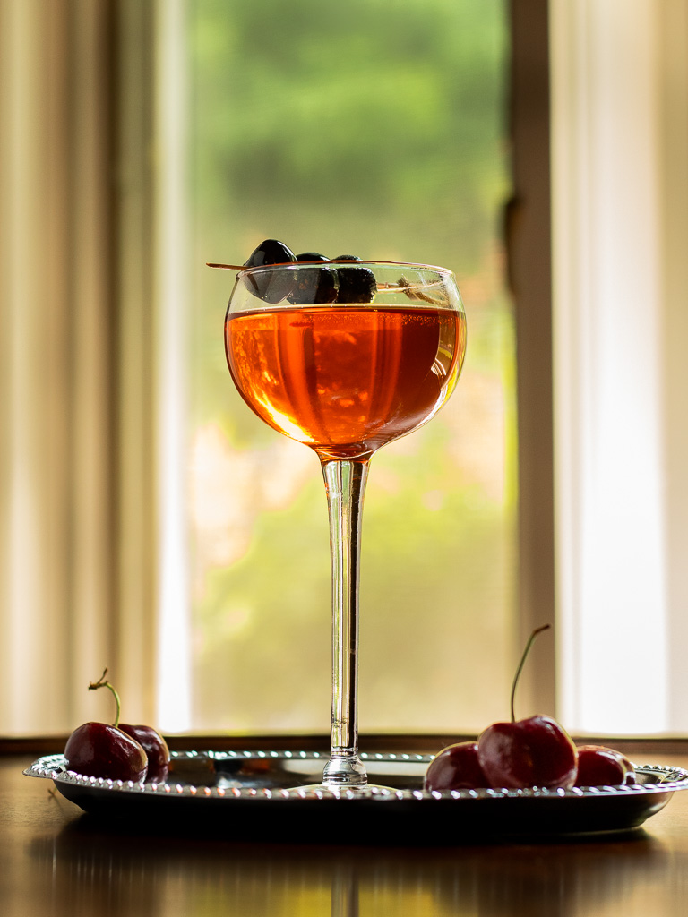 Little Italy cocktail in a tall coupe glass sitting on a silver serving tray.