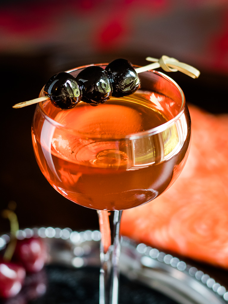 Aperol Manhattan - Little Italy in a coupe glass with a cherry garnish