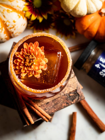 Pumpkin Spice Old Fashioned Thanksgiving Cocktail from overhead with cinnamon and flower garnish
