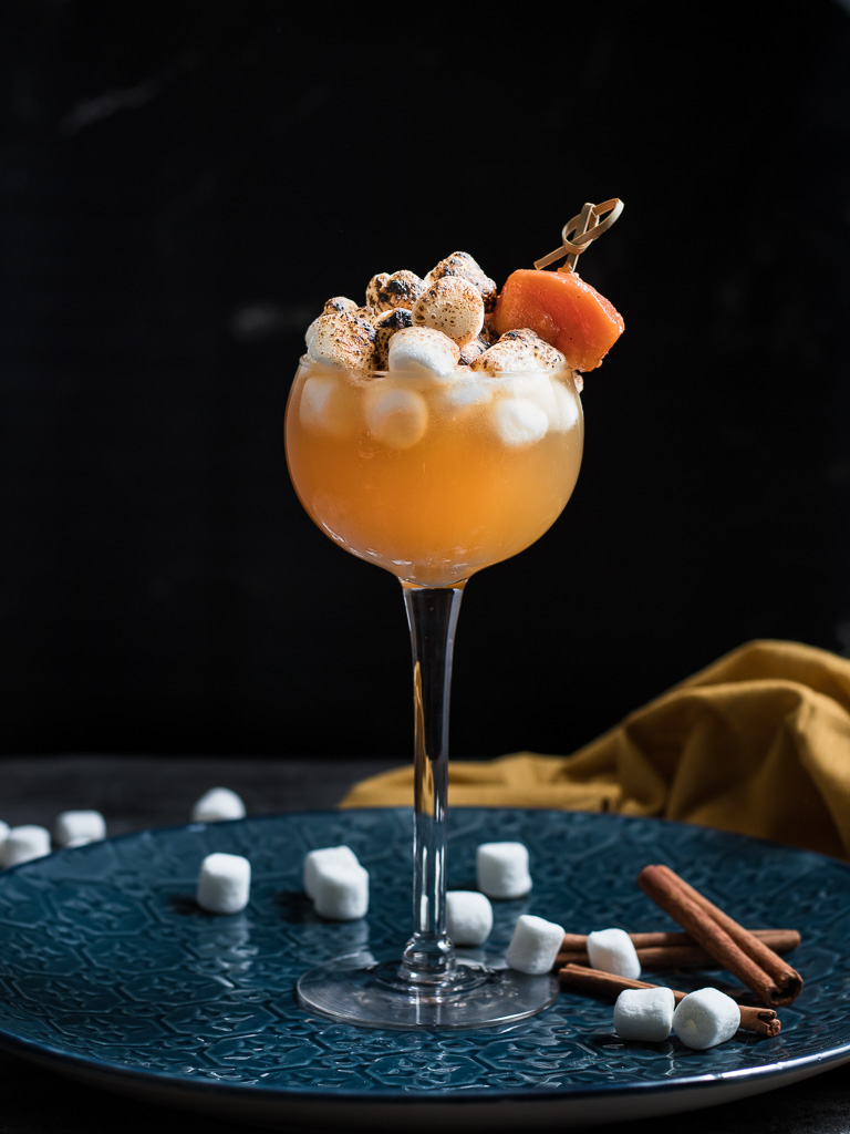 Sweet Potato Sour Thanksgiving Cocktail - on a blue plate, topped with toasted marshmallows