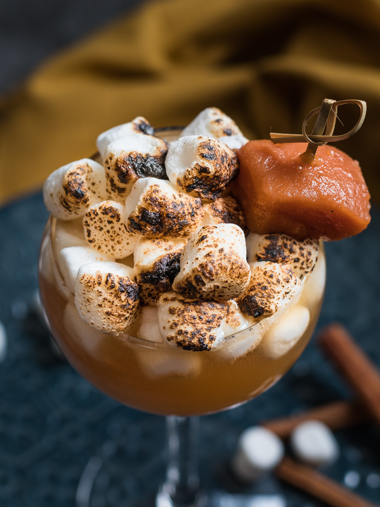 Sweet Potato Sour Thanksgiving Cocktail - on a blue plate, topped with toasted marshmallows