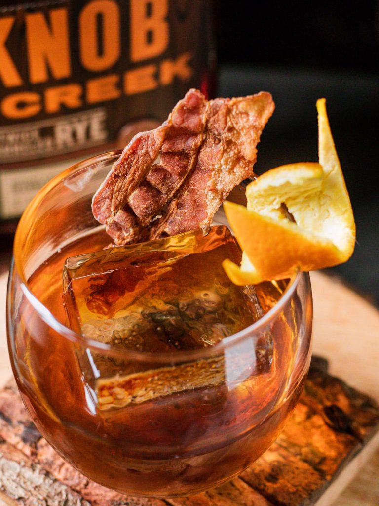 Maple Old Fashioned in a rocks glass with orange and bacon garnish