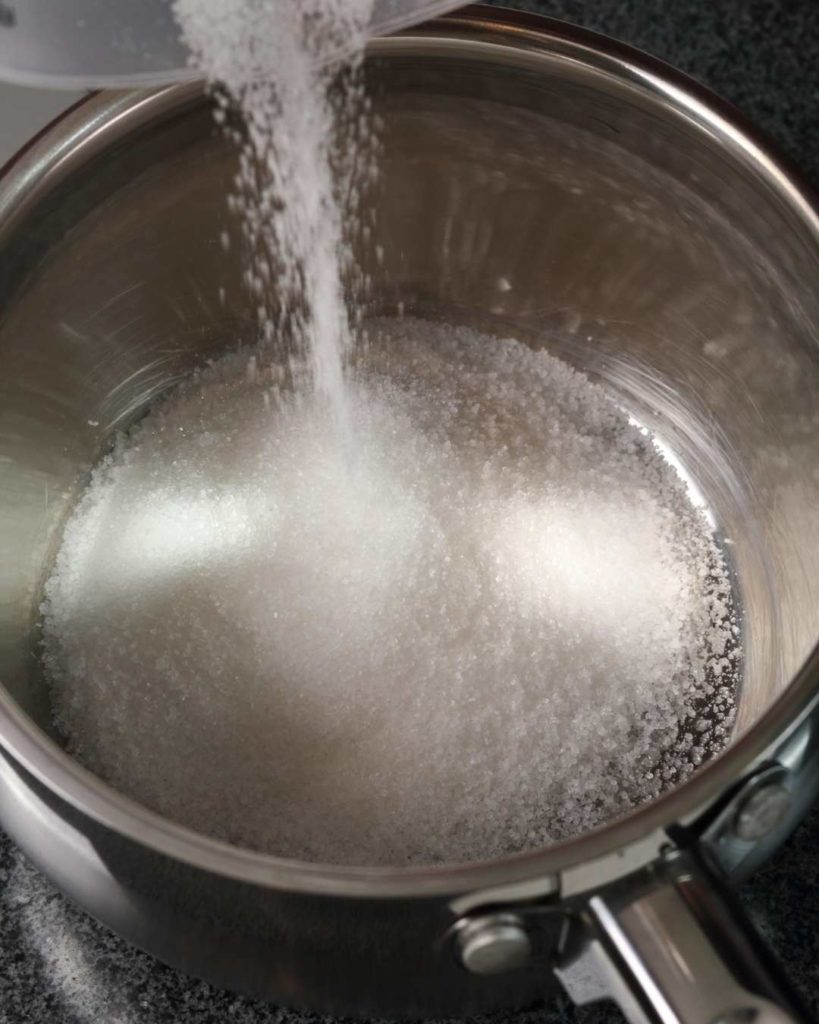 sugar being poured into a pan
