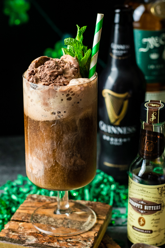 Beer float in tall glass with chocolate ice cream, mint, guinness stout and irish whiskey, with straw.